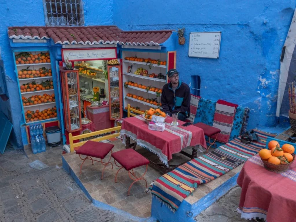 Calles estrechas y azules de Chefchaouen, la Ciudad Azul, con macetas y puertas coloridas.